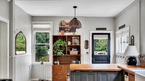 Una cucina con piano di lavoro in legno, lavello incassato e finestra vista verde.