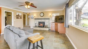 Una sala de estar con chimenea, un sofá, un televisor y un comedor.