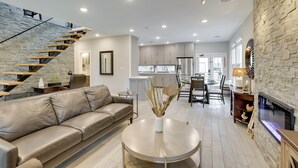 A modern living room with a leather sofa, a round coffee table, and a stone accent wall. - Pets Welcome: Home w/ Deck & Patio in Hockley! (Hockley)