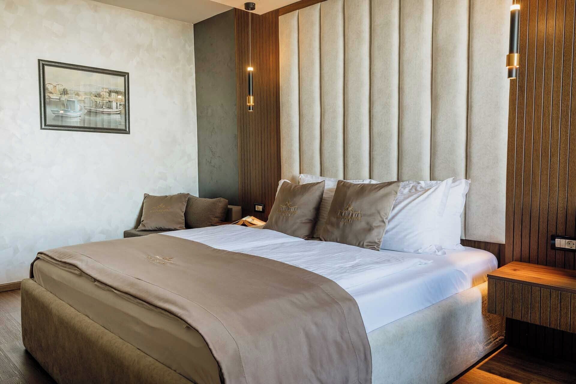 Un dormitorio moderno con una cama grande, cabecera con listones verticales y una mesita de noche con lámpara.