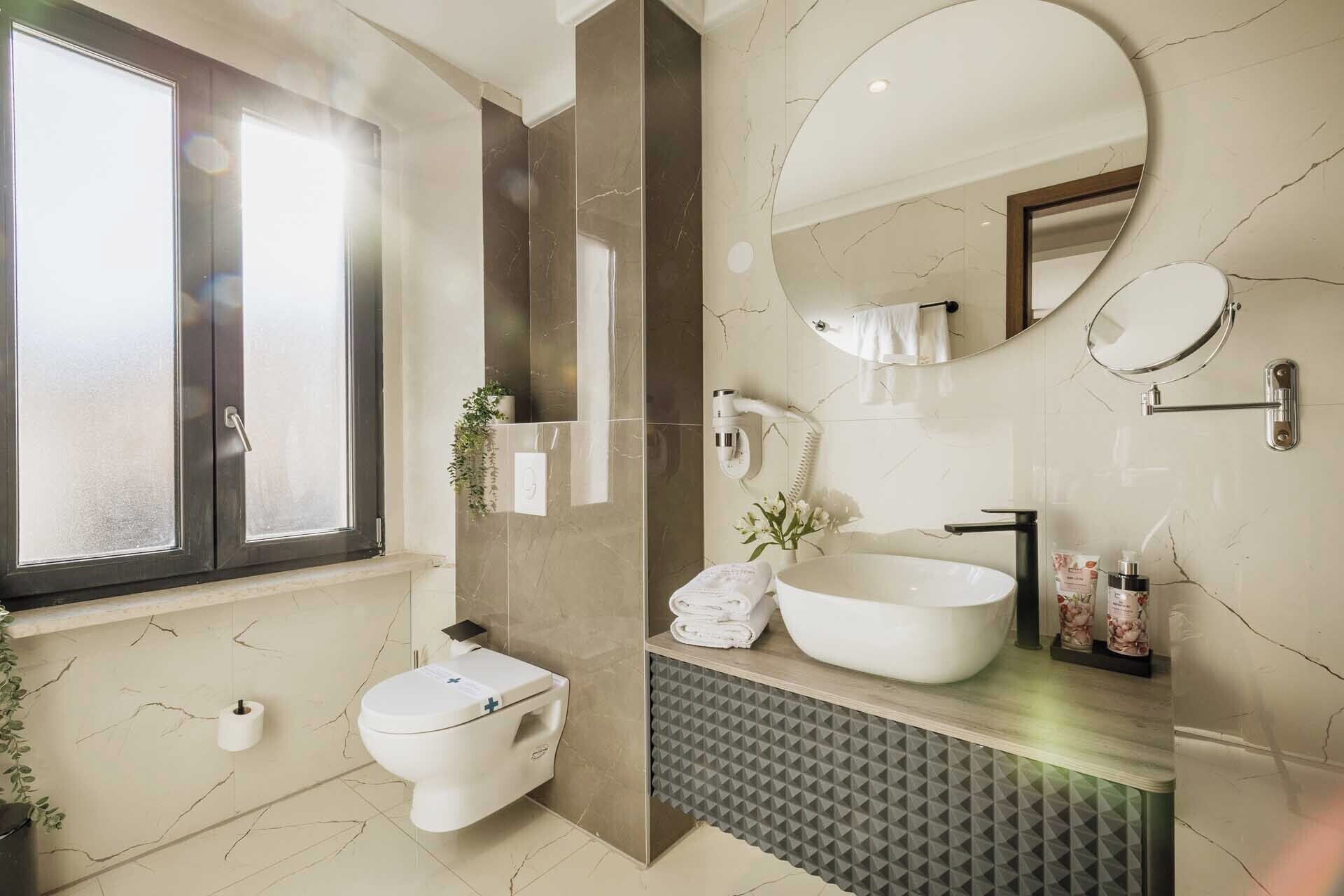 Un baño moderno con inodoro, lavabo, espejo y bidé.