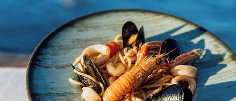 A seafood dish with mussels, shrimp, and squid on a plate.
