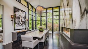 A modern dining area with a large table, chairs, and a chandelier. - Stunning 6 bed 5 bath estate on 65 acres with Pool, Hot Tub and Tennis Court! (Caledon Village)