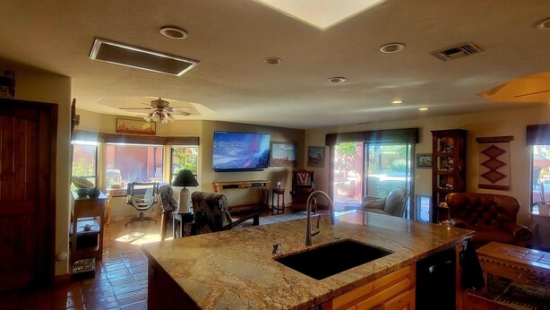 A spacious kitchen with granite countertops, a built-in sink, and a large flat-screen TV. - The Camelback Ranch in Litchfield Park - Amazing Backyard | Refreshing Pool (Litchfield Park)