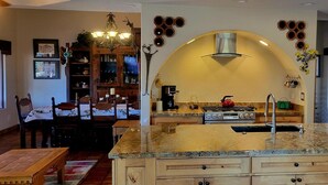 A kitchen with a central island, wooden cabinets, a stove, and a refrigerator. - The Camelback Ranch in Litchfield Park - Amazing Backyard | Refreshing Pool (Litchfield Park)