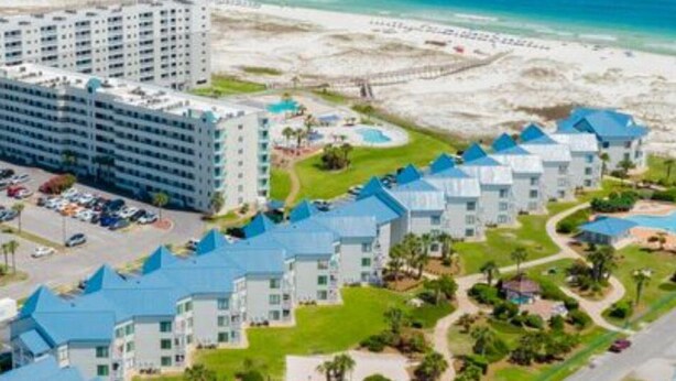Ein Resort mit mehreren Gebäuden, einem Pool und einem Strand.