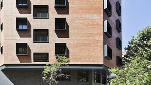 A modern building with a brick facade and multiple balconies. - Hotel Climent (Barcelona)