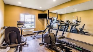 Un gimnasio con cintas de correr, elíptica y bicicleta estática.