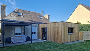 A modern house with a stone facade, a wooden extension, and a well-maintained lawn. - Our doll's house 2 steps from the shops and 800m from the beach. (Trébeurden)