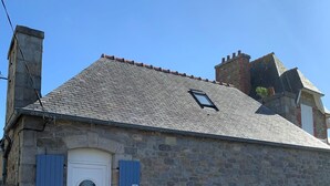 A stone building with a white door, blue shutters, and a small window. - Our doll's house 2 steps from the shops and 800m from the beach. (Trébeurden)