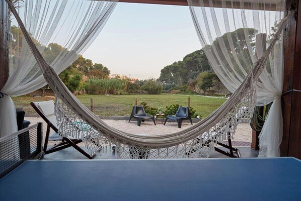 Una silla colgante con vistas a un área verde y árboles.