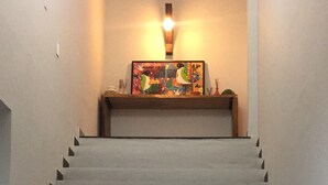Una escalera con una lámpara en la parte superior y un cuadro de colores en la barandilla.