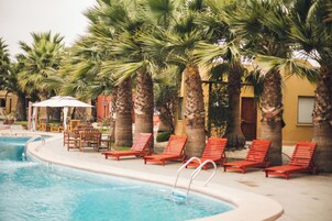 Una piscina al aire libre, tumbonas