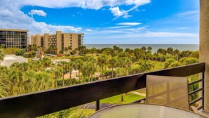 A balcony with a view of a resort area, including buildings and a beach. - Beachplace 3  - 302 by FGC (Longboat Key)