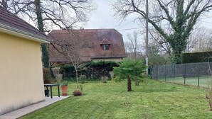 A grassy yard with a house in the background. - Semi-detached house in the countryside garden covered terrace (Lahourcade)