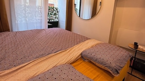 A hotel room with two beds, a large mirror, a TV, and a view of the outside balcony. - STUDIO COCON DeSIGN (Saint-André-les-Alpes)