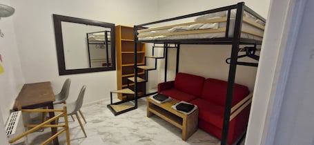 Chambre Quadruple Économique sans fenêtre (Noire) | Espacio para trabajar con un portátil y sistema de insonorización. Bed and breakfast chez l'habitant