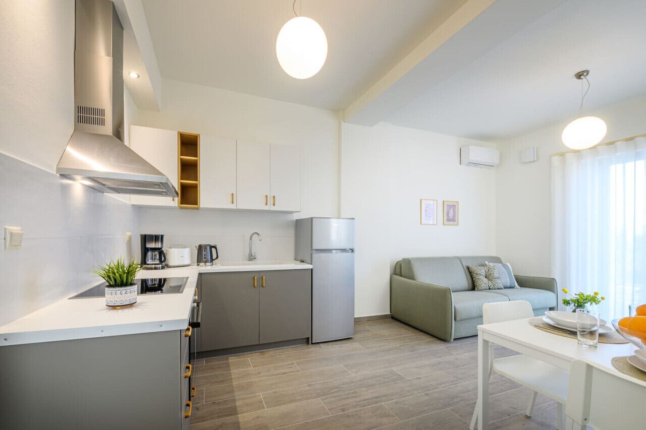 Une cuisine moderne équipée d’une cuisinière intégrée, d’un réfrigérateur et d’un coin repas avec une table et des chaises.