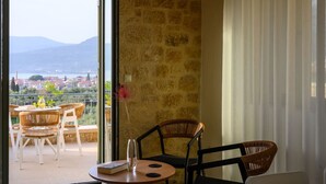A balcony with wicker chairs, a small table, and a vase with flowers. - Ipso Kardamyli Mythies (Kardamyli)