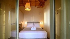 A modern hotel room with a large bed, bedside lamps, and a wooden ceiling. - Ipso Kardamyli Meropi (Kardamyli)