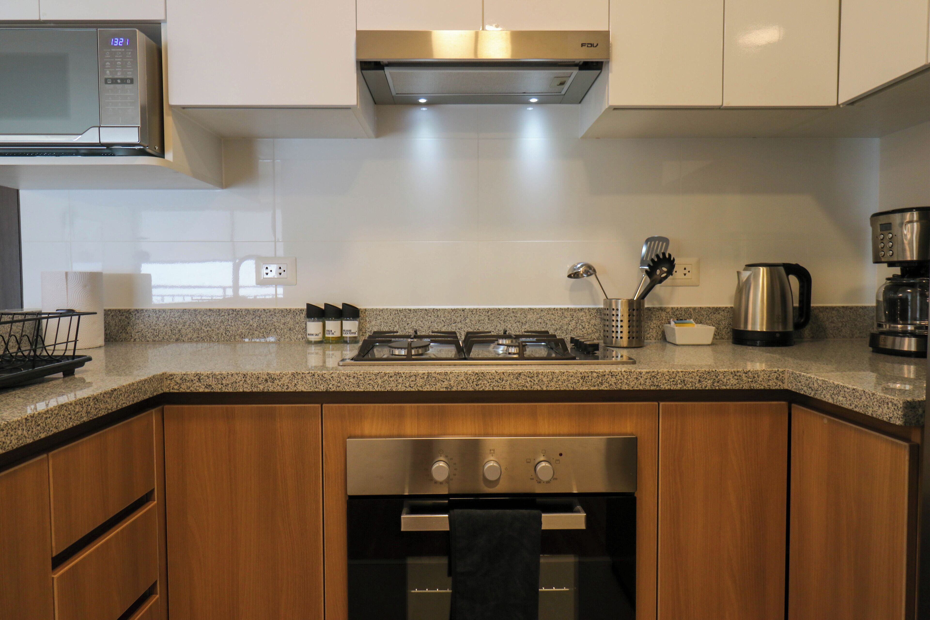 A kitchen with a microwave, stove, oven, and coffee maker.