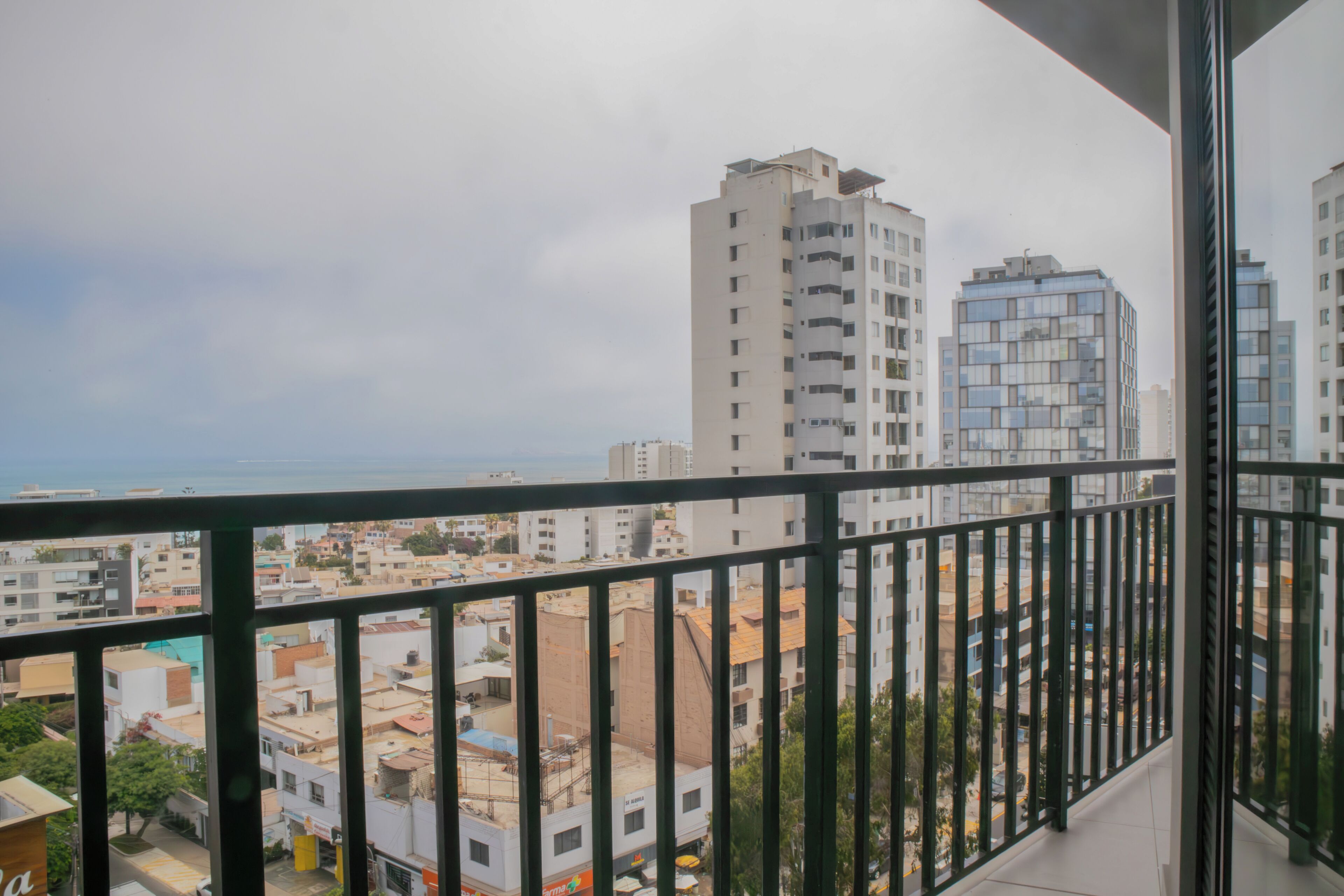 Un balcon donnant sur un paysage urbain et sur une étendue d’eau.