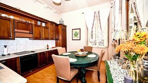 A kitchen with wooden cabinets, a dining table with chairs, and a vase with flowers.
