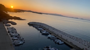 A marina with boats docked, a calm sea, and a sunset in the background. - Exceptional sea view, air conditioning, parking, private beaches, swimming pools, tennis court, marina. (Bandol)