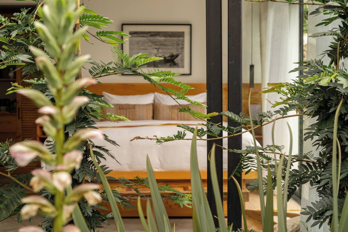 Een slaapkamer met een bed, een houten hoofdbord en een ingelijste foto aan de muur.