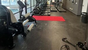 Una palestra con tapis roulant, macchinari ellittici e attrezzature per l'allenamento con i pesi.