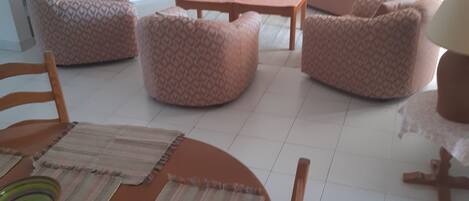 Una sala de estar con un conjunto de sofá, una mesa de centro y una mesa de comedor con sillas.