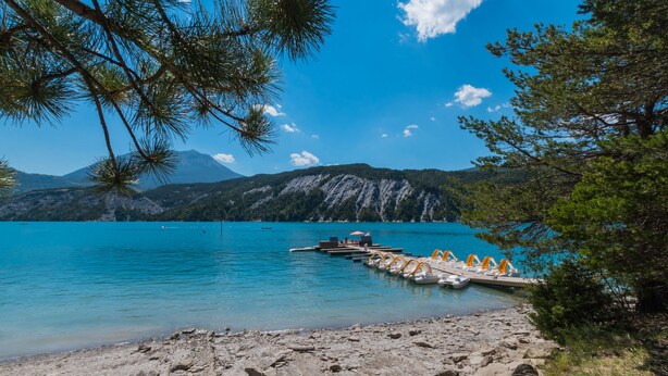 A lakeside scene with a dock, boats, and a mountainous backdrop. - Welcome to Casa Beausite (Gap)