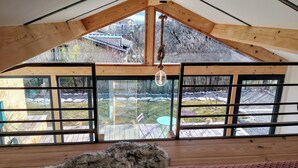 A high-ceilinged room with a sloped roof, large windows, and a hanging light fixture. - Welcome to Casa Beausite (Gap)