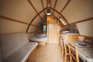 Une pièce confortable et compacte, dotée d’un lit en mezzanine, d’une petite kitchenette et d’un coin repas.