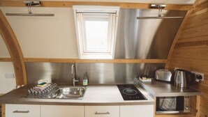 Une cuisine compacte équipée d’un évier, d’une cuisinière et d’un grille-pain.
