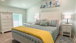 A bedroom with a bed, nightstands, a dresser, and a painting on the wall.