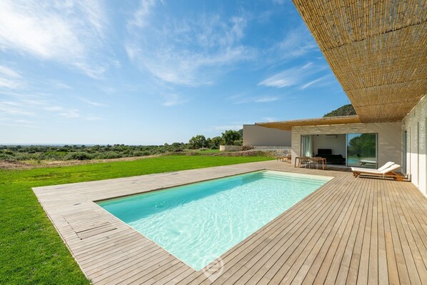 A modern house with a swimming pool, wooden deck, and a view of the countryside. - Villa Valentina (Pula)
