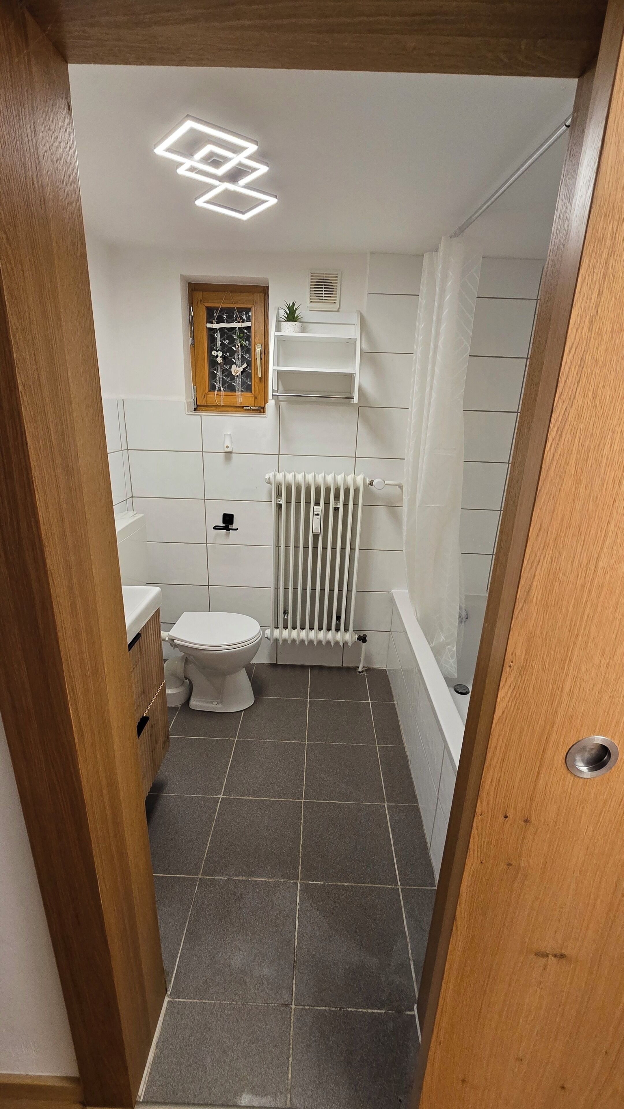 Kylpyhuone, jossa on wc, patteri ja suihkutila.