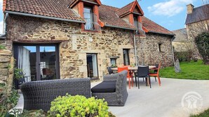 A stone house with a tiled roof, a balcony, and outdoor seating. - Tabata - PLOURHAN - Gîte (PLOURHAN)