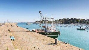 A harbor with boats docked, a paved walkway, and a clear blue sky. - Tabata - PLOURHAN - Gîte (PLOURHAN)