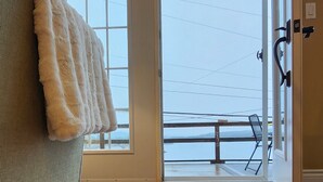 A room with a large window, a view of a balcony, and a door with a handle. - Pilley's Perch - Entire home in Pilley's Island, Canada. Beautiful Ocean View (Pilley's Island)
