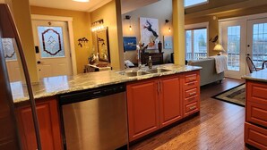 A modern kitchen with granite countertops, stainless steel appliances, and wooden cabinets. - Pilley's Perch - Entire home in Pilley's Island, Canada. Beautiful Ocean View (Pilley's Island)