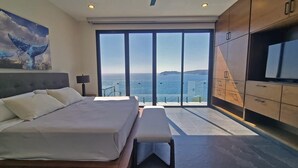 A bedroom with a large bed, a bench, a TV, and a view of the sea. - Casa Picos Palace with swimming pool and panoramic ocean view in Huatulco Bays (Santa María Huatulco)