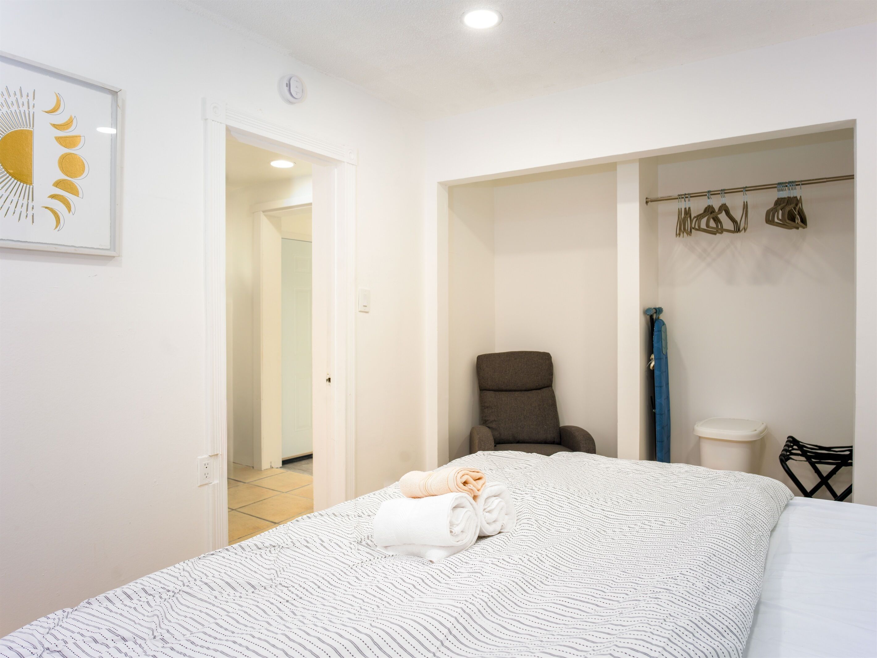 Une chambre à coucher comprenant un lit, une chaise, une salle de bain avec des toilettes et un espace douche.
