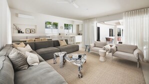 Un salon moderne avec un canapé gris, une table basse en marbre et un ventilateur de plafond.