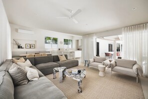 A modern living room with a grey sofa, a marble coffee table, and a ceiling fan.