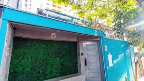 Een gevel met een groene wand, een metalen deur en een blauwe buitenkant.