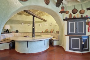 A kitchen with a central island, a hanging pot rack, and a cabinet with a decorative tassel. - The Grapefruit House - Villa con Piscina (Garlenda)