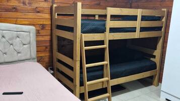 Uma cama de solteiro com escada, uma cama individual com cabeceira e piso revestido de azulejos.