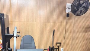 A gym with a bench press, weight bench, and various exercise equipment. - Chalezinho Pousada  (Santa Rita do Sapucaí)